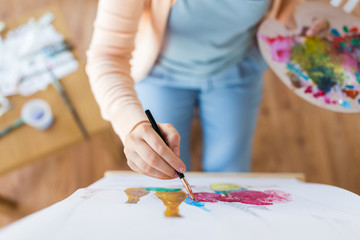 Naklejka premium artist with palette and brush painting at studio