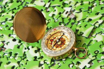 compass on pile of green puzzle