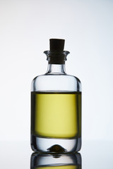 closed bottle of aromatic massage oil standing on reflective surface