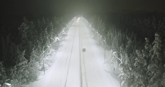aerial shot cars drive on winter night road during snowfall