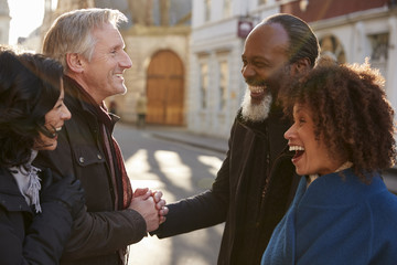 Group Of Mature Friends Meeting Outdoors In City