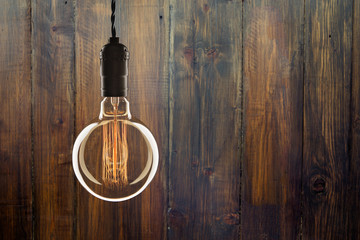 Vintage bulb on wooden background - idea, innovation and leadership concept. Space for text