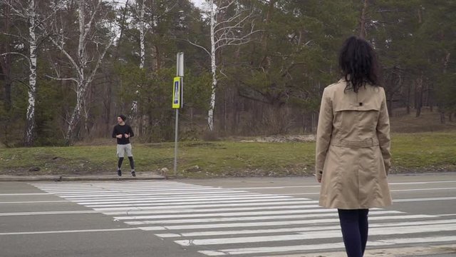 Young man and woman walks through crossroad and falls in love in each other