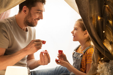 family playing tea party in kids tent at home