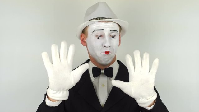 A sad mime shows tricks