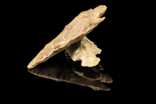 Two Indian arrowheads and black background