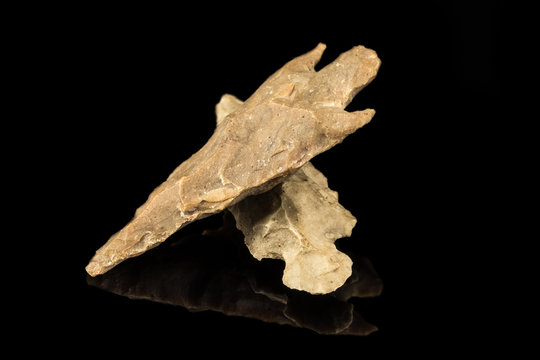 Two Indian arrowheads and black background