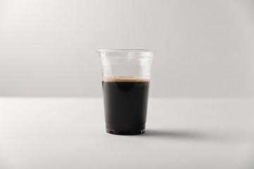 Disposable cup with black coffee on white background