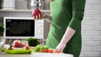 Hungry female holding red apple in hand for snack, healthy choice, vitamins