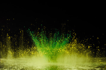 yellow and green holi powder explosion on black, Hindu spring festival