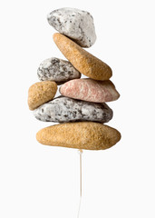 Fototapeta na wymiar A stack of stones over a pin representing the concept of holding weight.