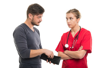 Male patient opening wallet next to female doctor.