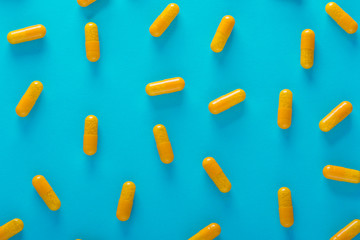 yellow pills on blue background top view