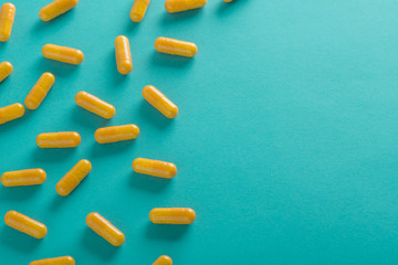 yellow pills on blue background top view