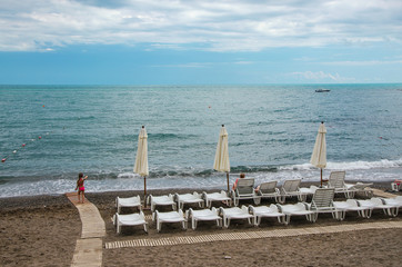 white chaise lounges and umbrellas in perspective on the beach. The sea, the sand.