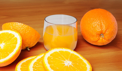 Orange juice glass with orange slices on a wooden background