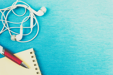 White headphones and wires on blue background. Copy space for text.