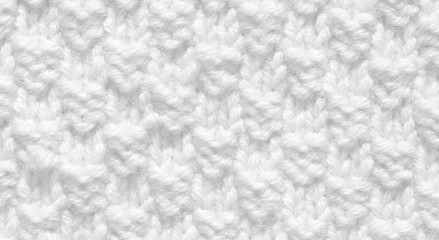 Knitting from woolen threads handmade. The texture is white, the background of the canvas is...