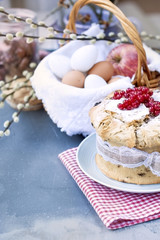 Sweet easter bread with berries, on the table by the window. Branches of a spring tree. The city is outside the window. Red napkin. Free space for text or a postcard.
