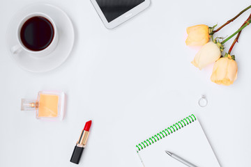 Frame mock up notebook with pen, flowers, perfume, lipstick,tablet and cup of coffee top view