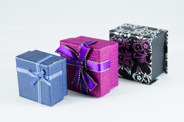 Close-up of blue, purple and black/white gift boxes lined up in a row.