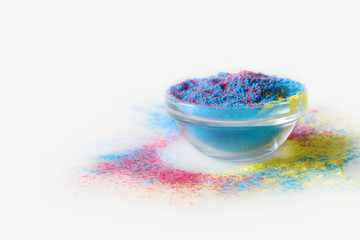 Indian Holi festival. Mix of blue and pink colours in bowl on white background.