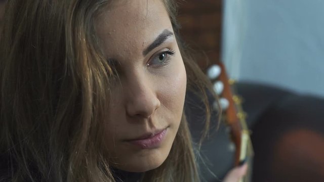 Teen girl playing the acoustic Guitar at home