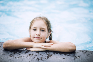 Little happy girl smiling and swimming in the outdoor pool beautiful and happy