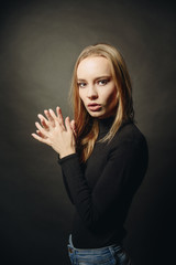 Fototapeta premium Wow. Close up portrait of cheerful coquette lady in black pullover over dark studio background.