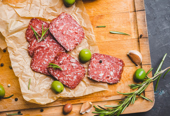 Delicious salami with olives, spices and rosemary. Selective focus.