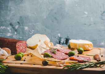 Delicious salami with olives, spices and rosemary. Selective focus.