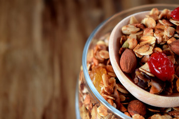 Granola in a glass jar and a wooden spoon. Rustic style