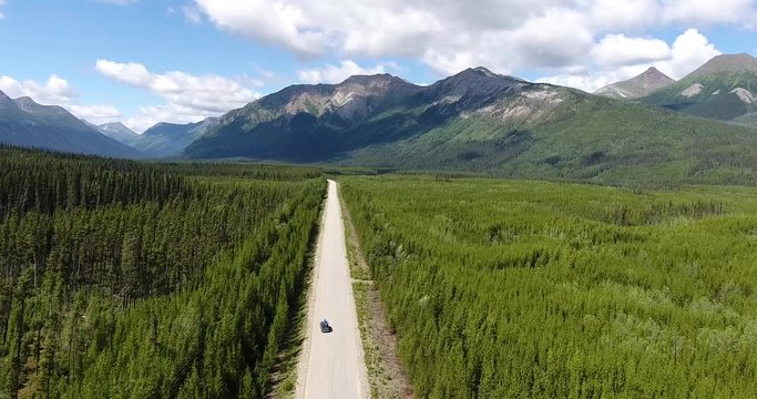 Van driving through lonely street in the forrest of alaska