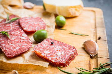 Delicious salami with olives, spices and rosemary. Selective focus.