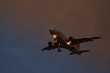 A plane taking off on the background of red yellow and blue sky