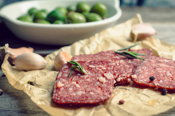 Delicious salami with olives, spices and rosemary. Selective focus.