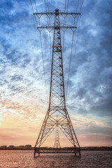 Electricity poles in the lake Buiten IJ with the Amsterdam district IJburg in the background.