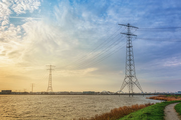 Electricity poles in the lake Buiten IJ with the Amsterdam district IJburg in the background.