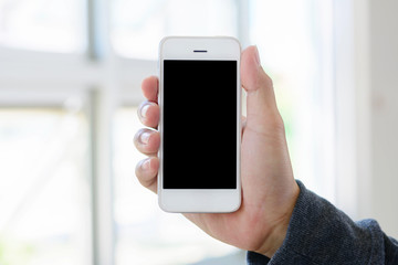 hand holding smartphone on abstract bokeh background