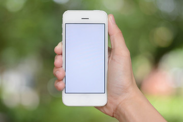 hand holding smartphone on abstract bokeh background