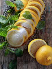 Lemon slices with sugar and mint leaves.