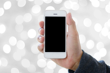 hand holding smartphone on abstract bokeh background