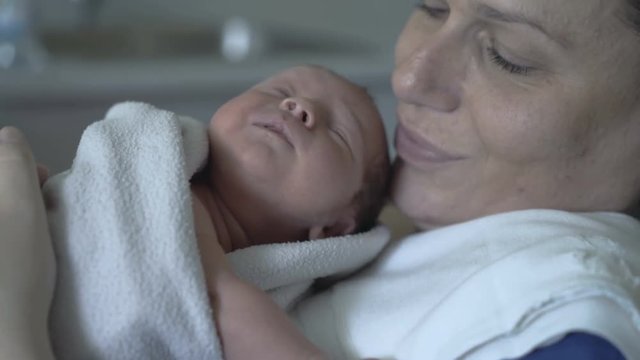 Newborn baby wakes up on her mother in the hospital
