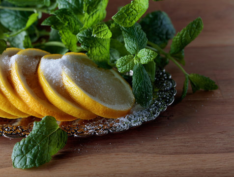 Lemon slices with sugar and mint leaves.