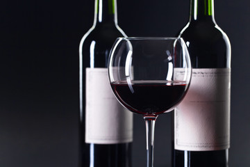 Bottles and glass of red wine .