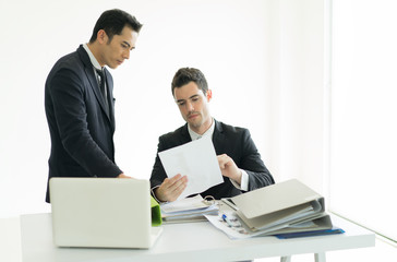 They are meeting new project so serius.Businessman looking at taplet and information in office.Businessman working at office with documents file on his desk.Meeting start up project