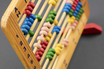 Wooden abacus / educational counting toy with 100 beads; on black background, closeup.