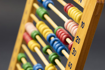 Wooden abacus / educational counting toy with 100 beads; on black background, closeup.