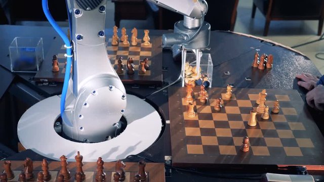 Close-up robot chessplayer playing chess with a himan.