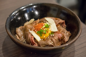 Gyudon, a Japanese dish consisting of a bowl of rice topped with rare beef with egg